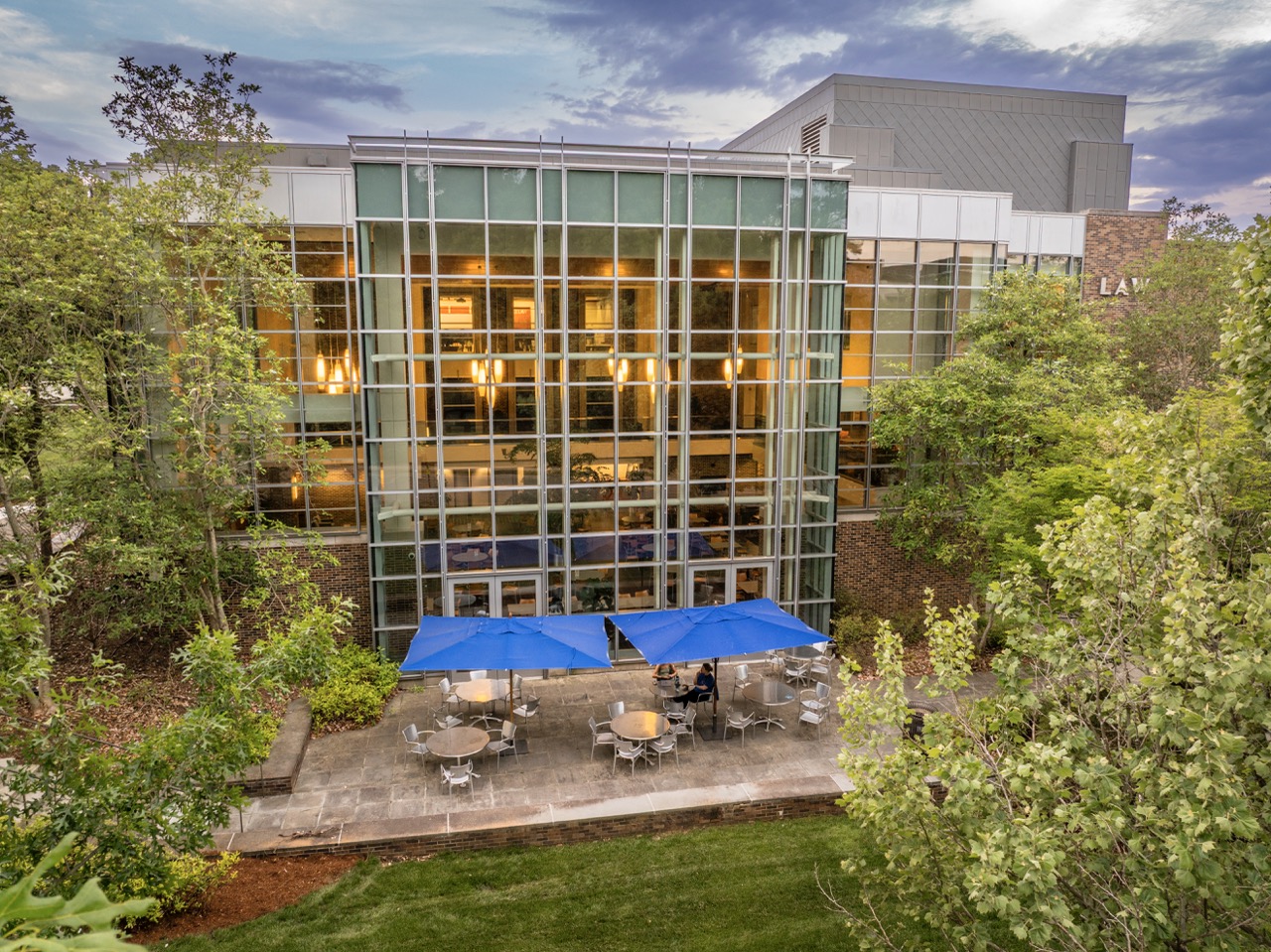 The Duke University School of Law building with tables outside with umbrellas